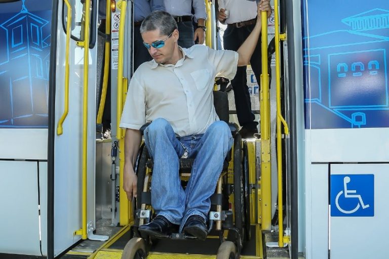 Homem na cadeira de rodas usa elevador para descer do ônibus