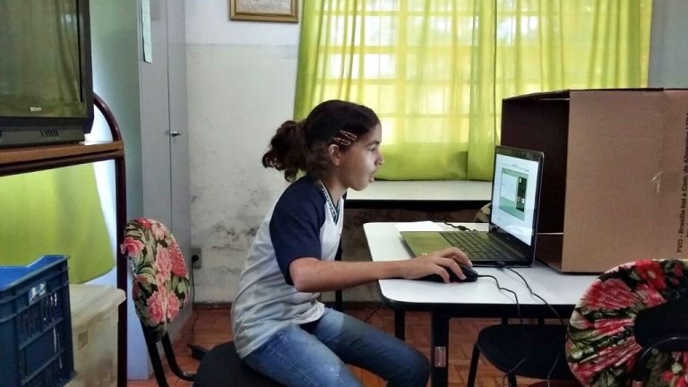 Menina em frente ao notebook assiste aula em casa