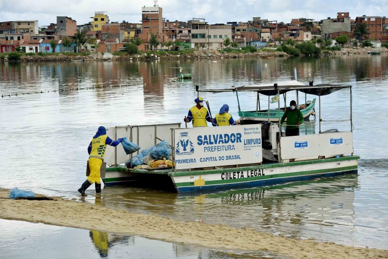 Gari coloca sacos de lixo em barco em favela de Salvador-BA)