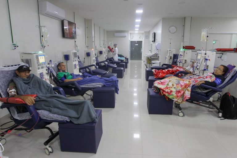 Pacientes estão deitados em poltronas fazendo hemodiálise
