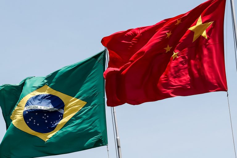 Bandeira do Brasil e da China hasteadas. Ao fundo o céu azul