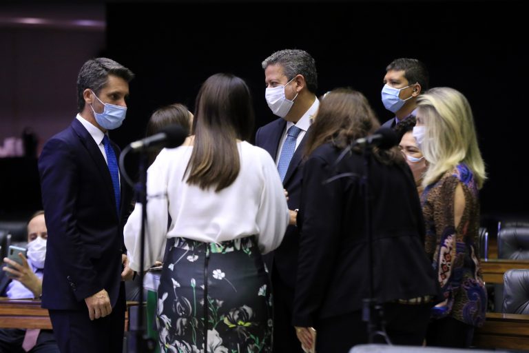 Deputados estão de máscara, em pé, conversando no Plenário da Câmara