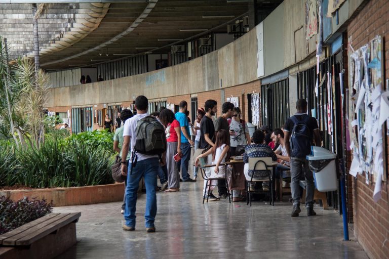 Alunos estão no corredor de uma universidade