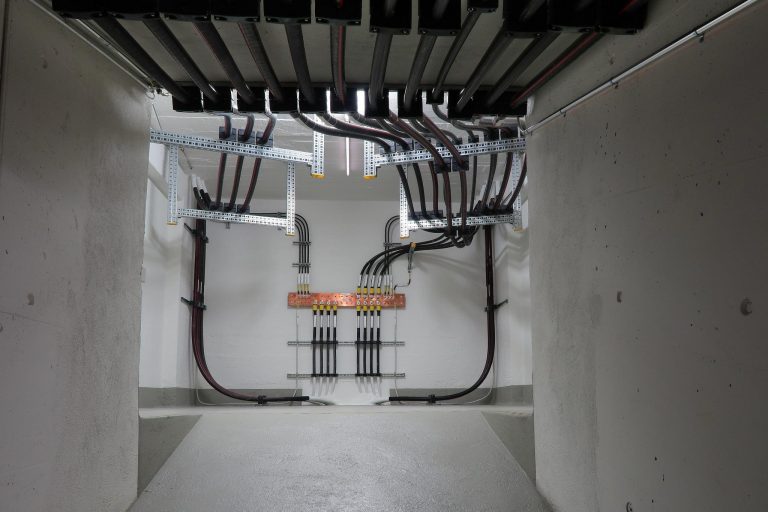 Fios de energia elétrica ao fundo de uma parede branca