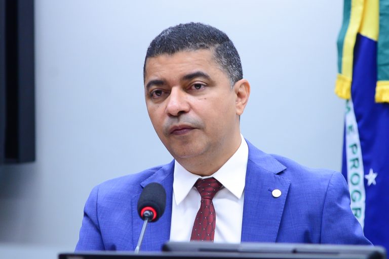 Deputado Bira do Pindaré está sentado falando ao microfone