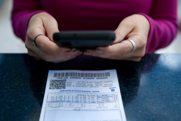 pessoa faz calculo diante de uma conta de água