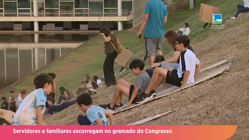 Servidores e familiares escorregam no gramado do Congresso